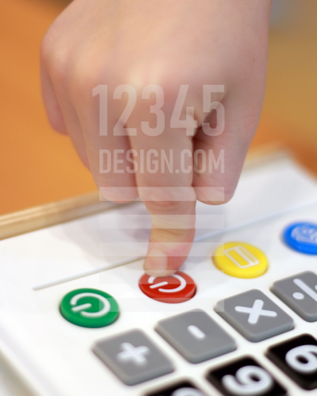 Children's hand presses off button calculator