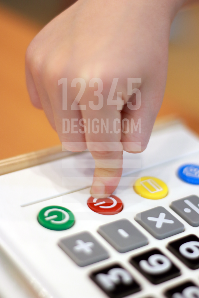 Children's hand presses off button calculator